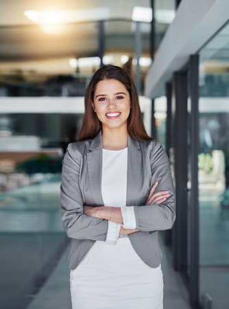 Ive got what it takes to succeed. Portrait of an attractive young businesswoman standing with her arms crossed in the office.の写真素材
