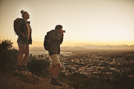 Never miss out on a great view. Rearview shot of a couple admiring the view from a mountain top.の写真素材