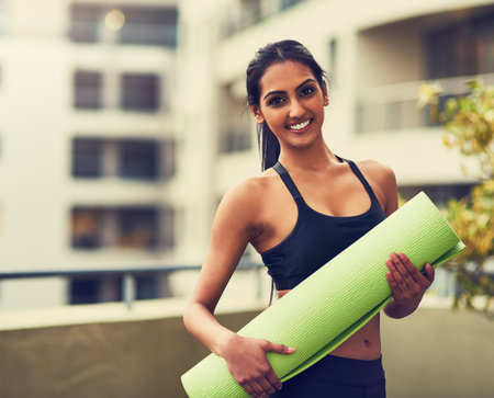 Yoga saves you time and money. a beautiful young woman practising yoga outdoors.の写真素材