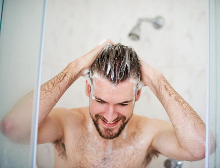 Shampoo and condition for a cleaner scalp. a handsome young man having a shower at home.