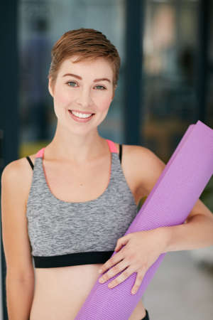The greatest wealth is good health. Portrait of a fit young woman holding an exercise mat.の写真素材