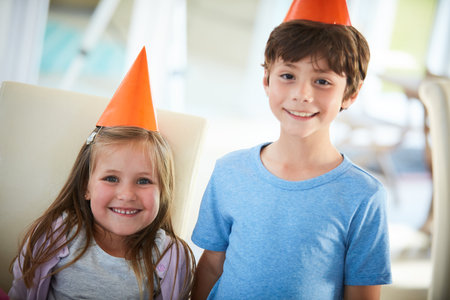 Let the celebrations begin. Portrait of a happy brother and sister having a birthday party at home.の写真素材