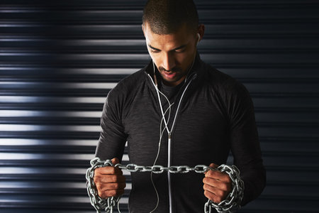 What doesnt challenge you doesnt change you. an athletic young man working out with a metal chain in the gym.の写真素材