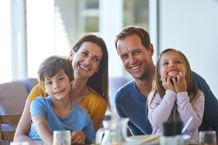 Even mealtime is a chance for quality time. Portrait of a family enjoying a meal together at home.の写真素材