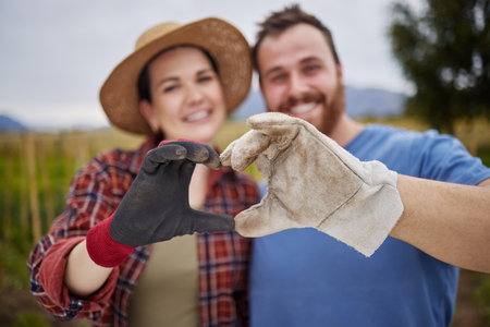 Farmer or gardener couple showing love heart sign with their hands outdoors on an organic or sustainable farm. Happy and excited activists support sustainability or organic farmingの写真素材