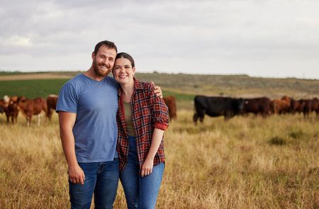 Farmer couple working on cow farm in the countryside for meat, beef and cattle food industry on sustainability field, agriculture environment and nature land. Portrait of happy people farming animalsの写真素材