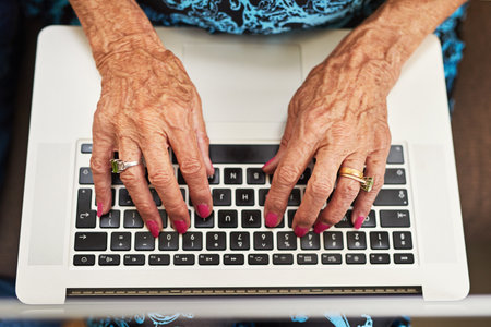Life experience makes for great blog content. a senior woman typing on a laptop keyboard.