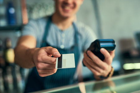 Your card...an unrecognizable barista taking a credit card payment.の写真素材