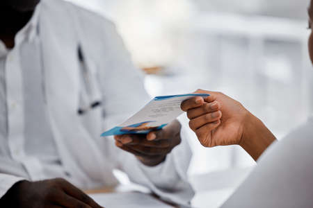 Hands of doctor giving flyer to patient about hospital help, medical clinic contact us information....