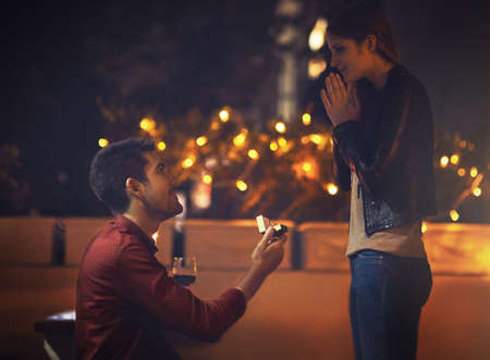 You deserve a promotion, babe. a young man going on his knees during his proposal.の写真素材