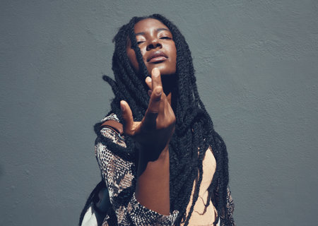 Beauty, culture and heritage with a black woman in studio against a gray background. Portrait of a beautiful african american female with braided hair posing and feeling confident with attitudeの写真素材