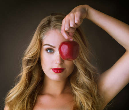 Hard to look away from her hypnotizing allure. Studio shot of a gorgeous young woman holding a red...
