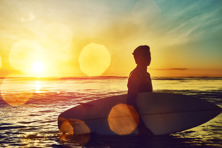 Learn to be in harmony with nature. a young boy out surfing.の写真素材