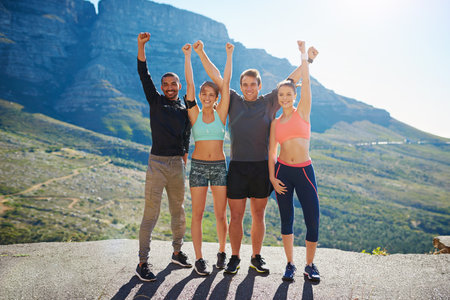 It pays to have a healthier outlook on life. Portrait of a fitness group celebrating after a workout outside.の写真素材