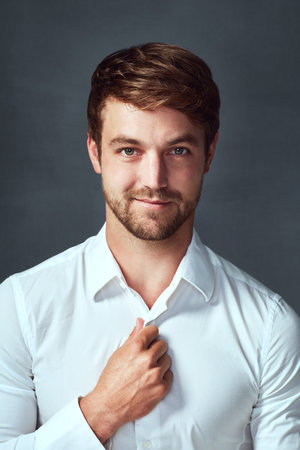 No tie, no problem. Studio portrait of a handsome young man posing against a grey background.の写真素材