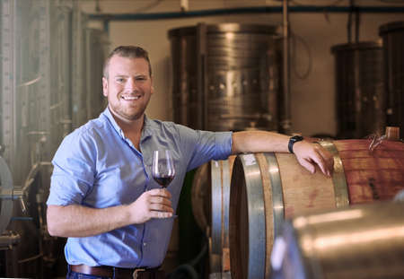 These wines dont just taste good, they do good...a man enjoying wine tasting in his distillery.の写真素材