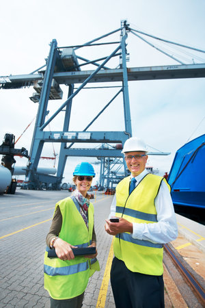 Industry workers working on a shipping dock to export stock packages, boxes or containers. Portrait...