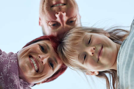 Were happy together. Low angle portrait of a cute little girl and her parents putting their heads...