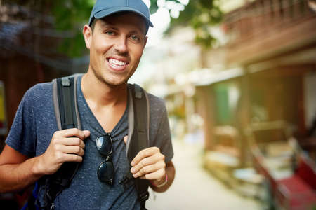 Time to do some sightseeing. Portrait of a smiling young man wearing a backpack traveling in...