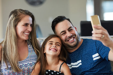 Its another beautiful moment worth capturing. a family taking a selfie together at home.の写真素材