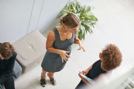 Talking business in the company corridors. High angle shot of two businesswomen talking together in a modern office.の写真素材
