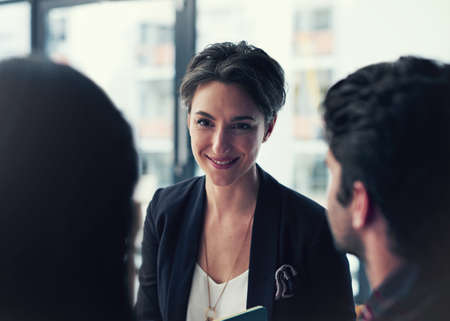 Making time to connect as a team. a group of colleagues having a discussion in a modern office.