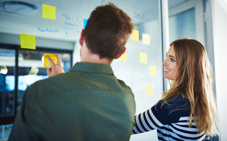 Encouraging creativity with her colleague. colleagues having a brainstorming session with sticky...