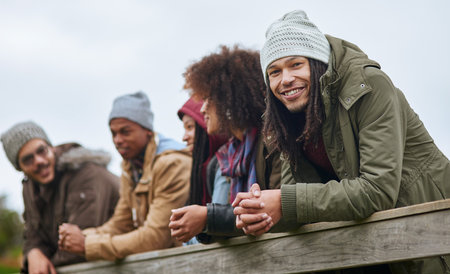 Were dedicated to having a good time. Portrait of a happy young man hanging out on a wooden bridge with his friends.の写真素材
