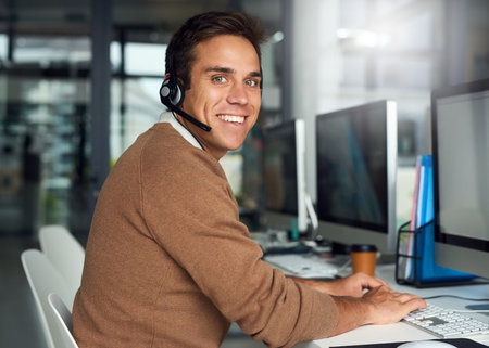Committed to quality customer service. Portrait of a young call centre agent working in an office.