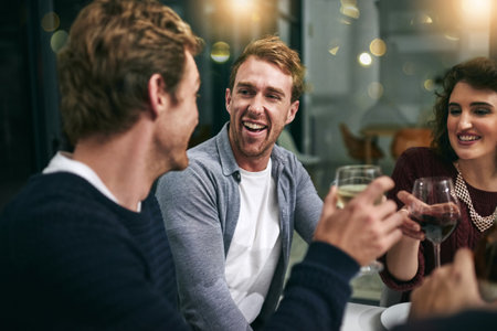 Having a laugh. two young men talking and laughing during a dinner party at a restaurant.