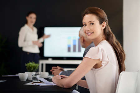 Success will be ours soon. Portrait of a young businesswoman sitting in a boardroom with colleagues...
