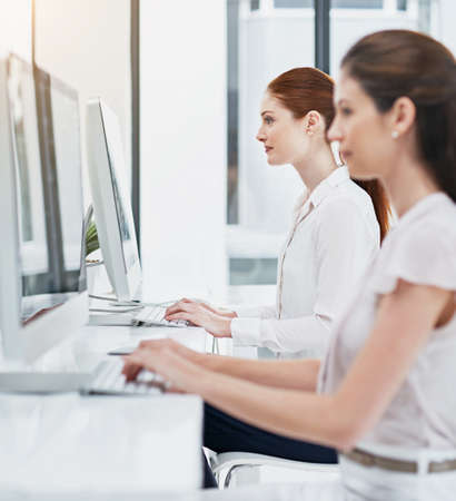 Assisting customers online. businesswomen working at their desk.の写真素材