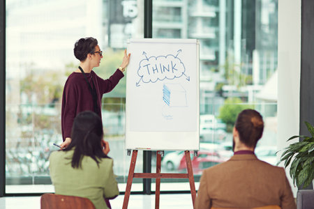 Think big, achieve bigger. a young creative giving a presentation to her colleagues in an office.
