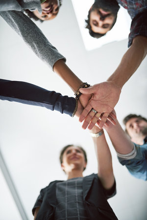 Unity is the secret to their success. a group of creative businesspeople stacking their hands on top of each other.の写真素材