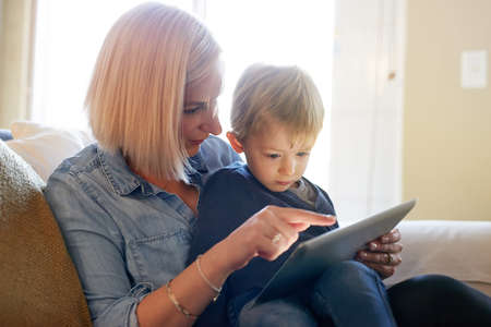 Moms downloaded him a safe new app to play on. a mother and son using a digital tablet together at...