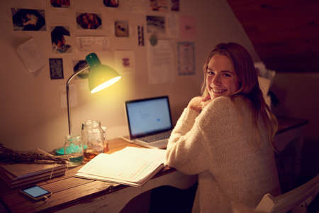 Burning the midnight oil. Portrait of a young woman using her laptop in her bedroom at night.