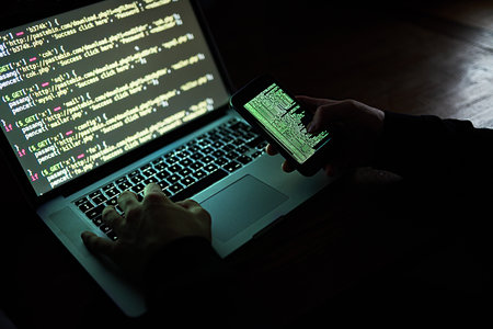 How safe are you online. an unidentifiable hacker using a laptop late at night.の写真素材