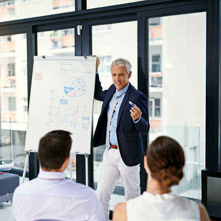 This is a challenge but well make it work. a businessman giving a presentation to colleagues in an office.の写真素材