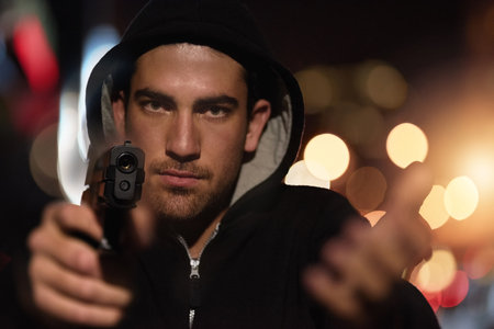 Give me your money. Portrait of a thief holding you at gunpoint.