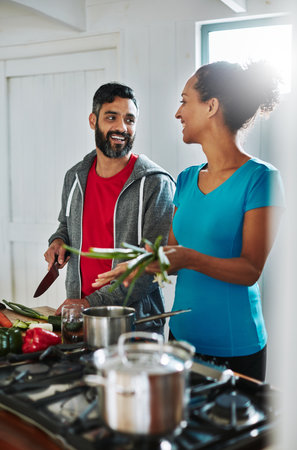 Youre my favourite sous chef. a happy couple cooking together in their kitchen at home.の写真素材