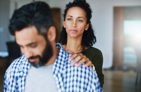 Talk to me, sweetheart. a woman comforting her distraught husband at home.の写真素材