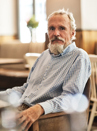 Ive been coming here for years. Portrait of a happy senior man sitting at a table in his favorite cafe.の写真素材