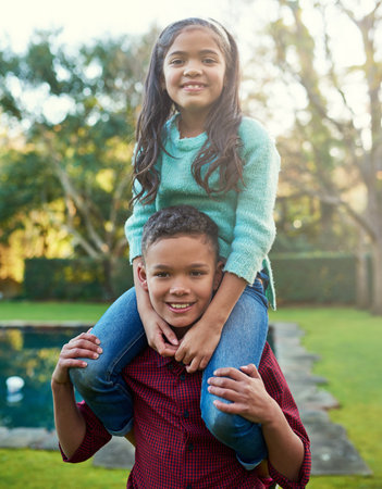 That special sibling bond. Portrait of a happy little girl being carried by her brother outdoors.の写真素材