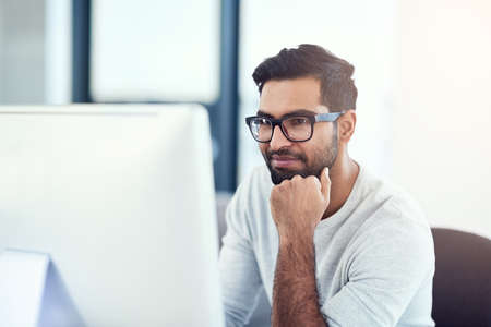 Hes impressing himself. a young man working in his office.