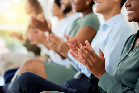 Business people clapping hands at corporate seminar in a modern, creative and company building. Closeup of happy audience celebrating, cheering and listening to ceo presenter at an office tradeshow.の写真素材