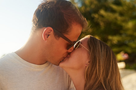 Kisses on the coast. an affectionate young couple on the beach at sunset.