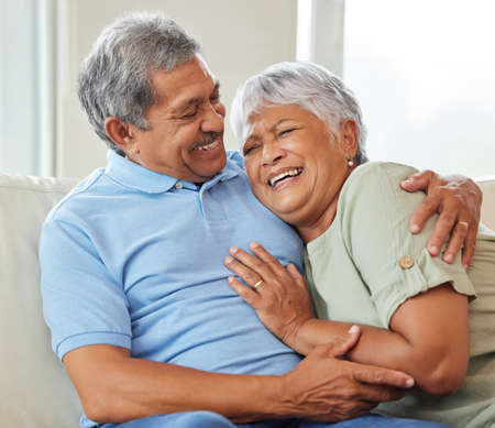 Love, care and happy senior couple hugging each other while bonding and relaxing on sofa at home....
