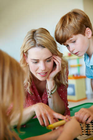 Taking the time to connect with her kids through play. a mother having fun with her two kids at...