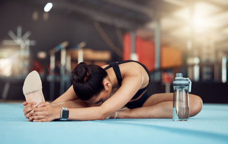 Woman stretching legs for fitness training at gym, yoga for exercise at health club and sports workout for wellness and strong body. Gymnast doing pilates and gymnastics on floor for cardio sportの写真素材