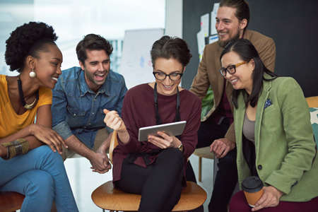 We work smart, not hard. a group of creative businesspeople looking at something on a tablet.